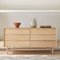 a wooden dresser with two vases on top of it