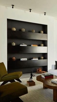 a modern living room with black shelves and white furniture