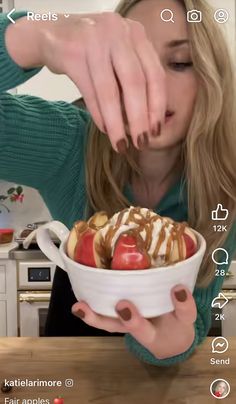 a woman holding a bowl of food in her hands and touching it with her hand