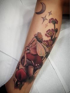 a woman's leg with a mushroom and flower tattoo on her left calf area