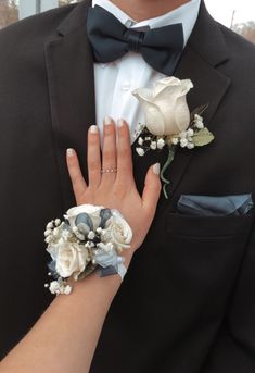 a man in a tuxedo with flowers on his wrist