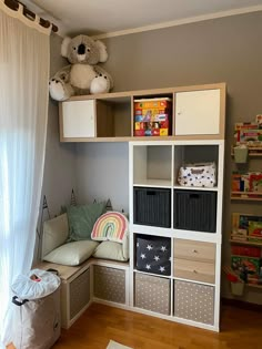 a child's playroom with toys, bookshelves and storage bins