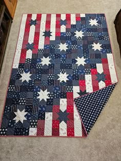 an american flag quilt is laying on the floor