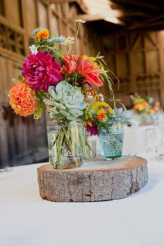 there are many flowers in vases on the table