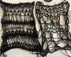 two pieces of black crochet sitting next to each other