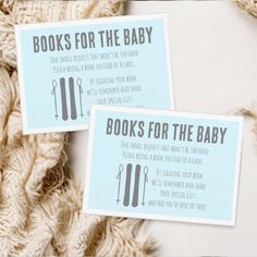 two books for the baby cards sitting on top of a pile of yarn next to each other