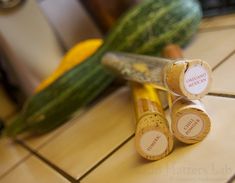 three wine corks sitting on top of a tiled floor next to cucumbers