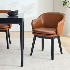 two brown chairs sitting next to each other on top of a white carpeted floor