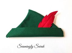 a green hat with a red feather on it and the words seamany sarch written below