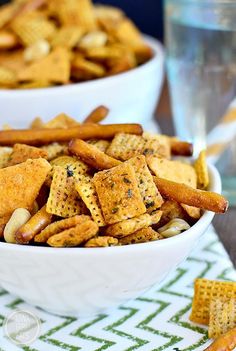 two white bowls filled with cheetos sitting on top of a green and white table cloth