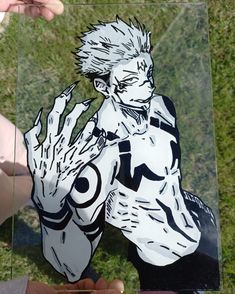 a person holding up a cut out of an anime character