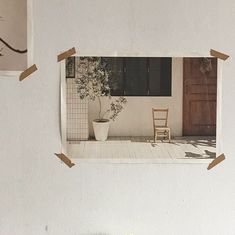 a white wall with pictures hanging on it and a chair in front of the door