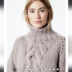 a woman wearing a gray turtle neck sweater