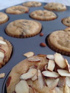 a muffin tin filled with cupcakes covered in almonds and chocolate chips