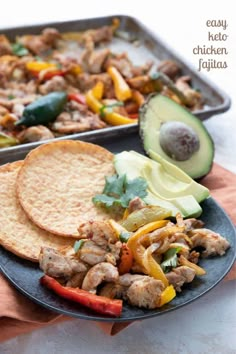 chicken fajita on a plate next to an avocado and pita bread