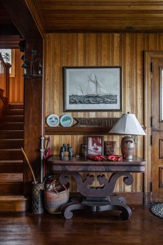 a room with wood paneling and a lamp on the table in front of it