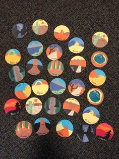 several different colored stickers sitting on top of a black carpet next to a person's feet