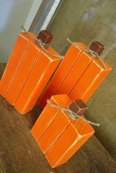 three orange candles sitting on top of a wooden table