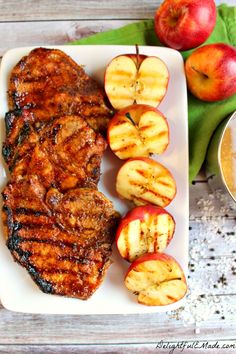 grilled pork chops and apples on a white plate