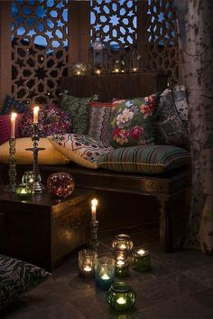 a living room with candles and pillows on the couch