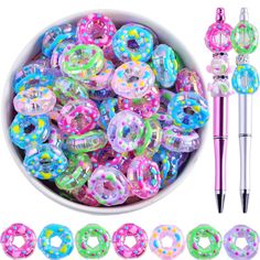 a bowl filled with lots of colorful plastic donuts next to a pen and marker