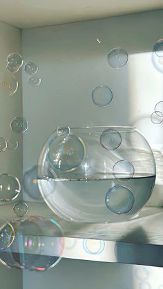 soap bubbles floating in a bowl on top of a shelf next to a wall mounted mirror