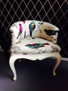 a white chair with colorful birds painted on it's armrests and back