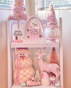 a shelf filled with pink and white christmas decorations