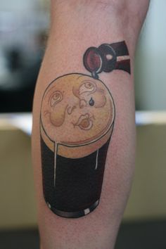 a man with a beer tattoo on his leg holding a glass and a ketchup bottle