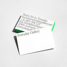 two business cards sitting on top of each other with black and green ink in them