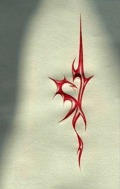 a red tattoo design on white paper with a shadow from the wall behind it and a person's head in the background