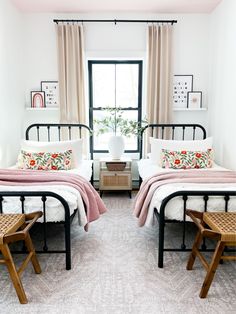 two twin beds in a bedroom with pink and white bedding on the covers, pillows and blankets