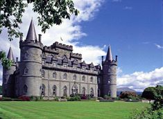 an old castle with towers and grass in the foreground