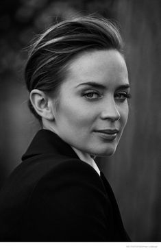 a black and white photo of a woman with her hair in a high pony tail