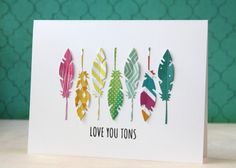 a card with colorful feathers and the words love you tons