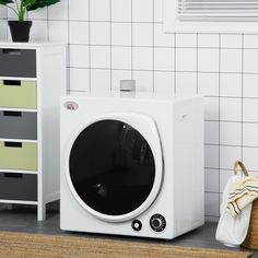 a white microwave oven sitting on top of a counter next to a potted plant