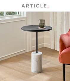 a table with a cup on it in front of a chair and another orange chair