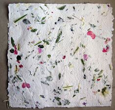 a piece of paper that has been made with different colored flowers and leaves on it