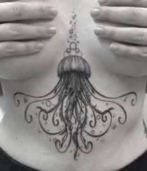 a woman's chest with an octopus tattoo on her stomach and hands covering her face