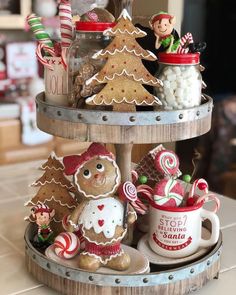 a three tiered tray with christmas cookies and candies