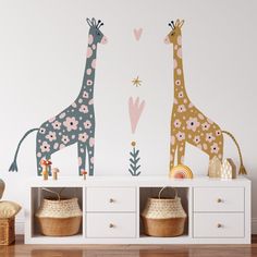 two giraffes standing next to each other on top of a white shelf