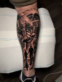 a man's leg with a black and grey tattoo on it that has an image of two people holding hands