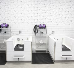 three white sinks in a bathroom with black and white tiles on the wall behind them