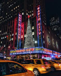 the radio city christmas tree is lit up at night