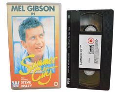 an old cassette with the label for mel gibson's summer city, next to it