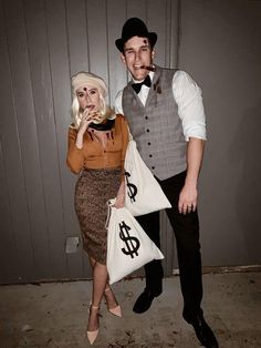 a man and woman are dressed up for halloween with money bags in front of them