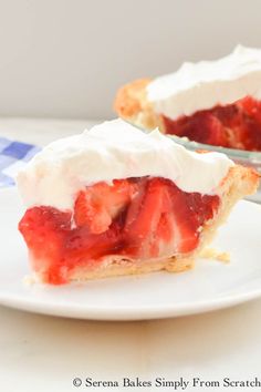 a slice of strawberry shortcake on a plate next to a bowl of strawberries