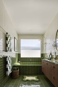 a bathroom with green tile and wooden cabinets, along with a rug on the floor