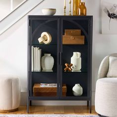 a black bookcase with books and vases on it