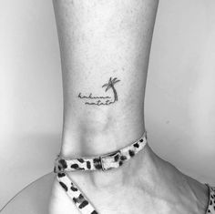 a black and white photo of a woman's foot with a palm tree tattoo